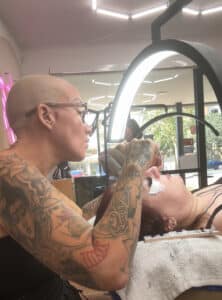 "Kayla Marie applying mega lash extensions while Katrina provides injectable treatments at Third Eye Beauty Lounge in Tempe, AZ