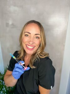 Katrina, cosmetic injector at Third Eye Beauty Lounge in Tempe, holding a syringe of Juvéderm dermal filler before a treatment.
